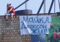 В Н.Новгороде молодой человек ходит по краю крыши высотного дома с плакатом "Майкл Джексон жив" (фото)